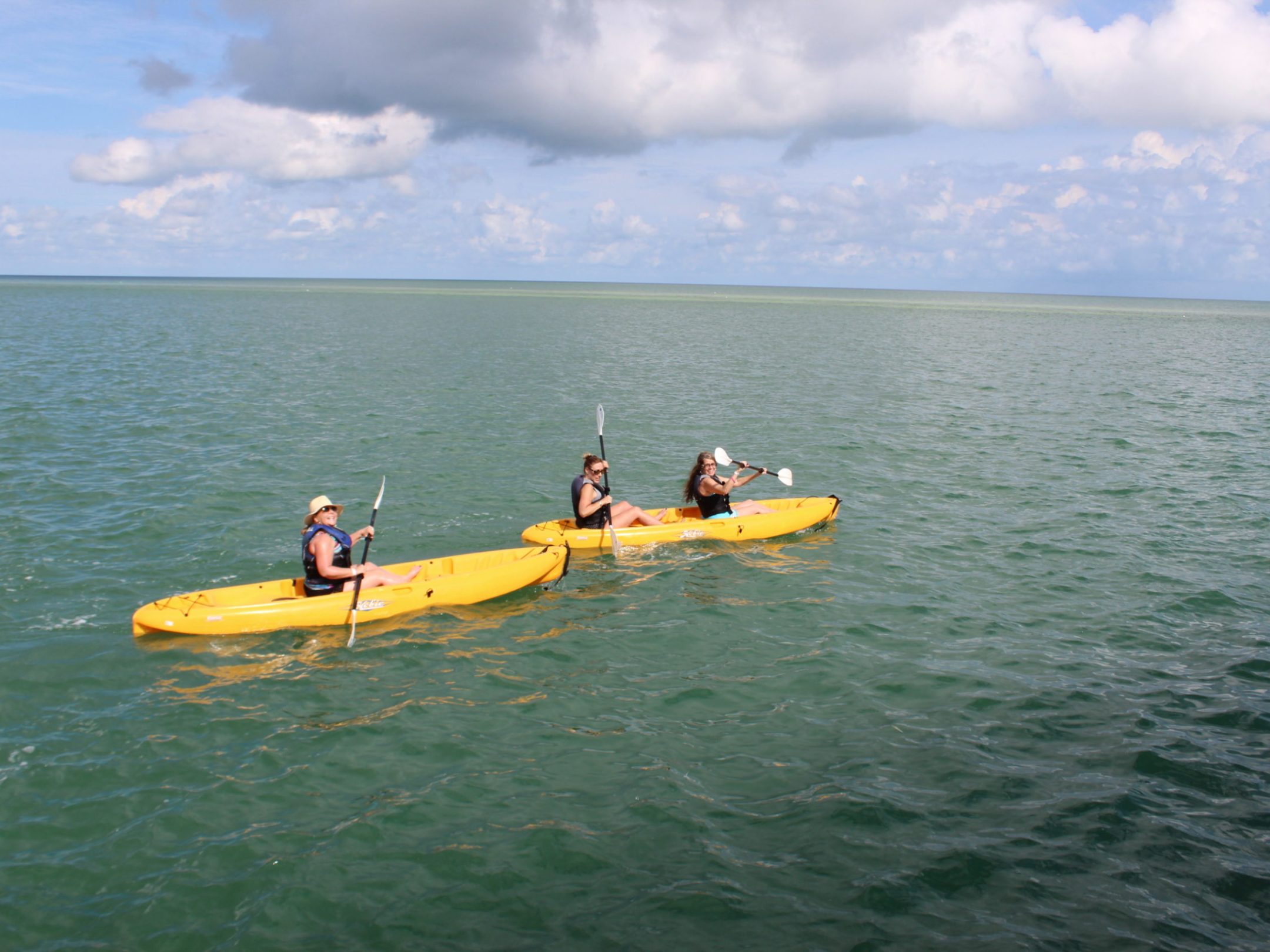 a group of people riding on the back of a boat in the water