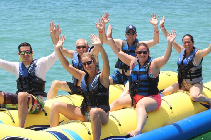 a group of people sitting next to a body of water