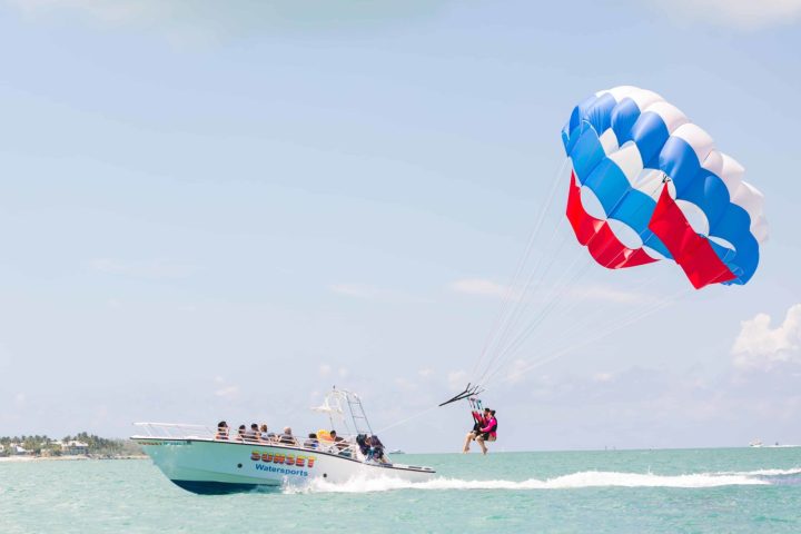 a man flying a kite in a boat on a body of water