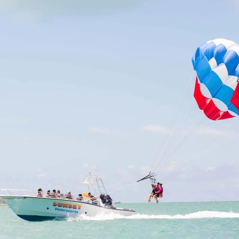 a man flying a kite in a boat on a body of water